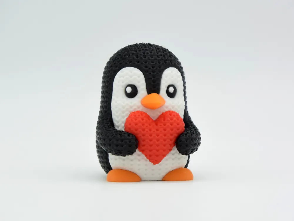 Figurine pingouin au cœur kawaii effet tricoté, vue de profil