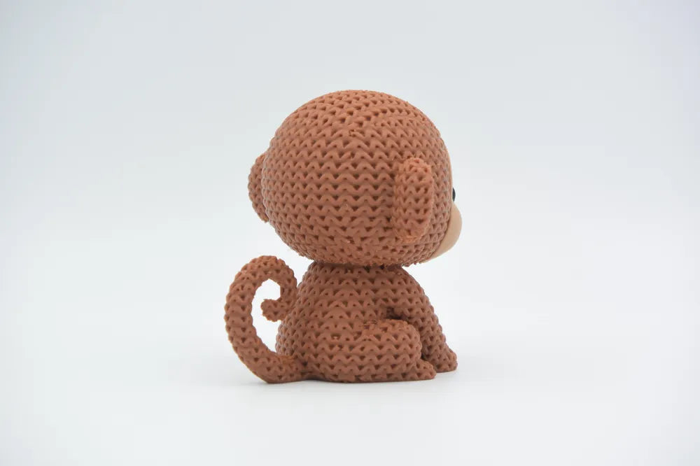 Figurine singe kawaii effet tricoté, détail de la texture tricotée
